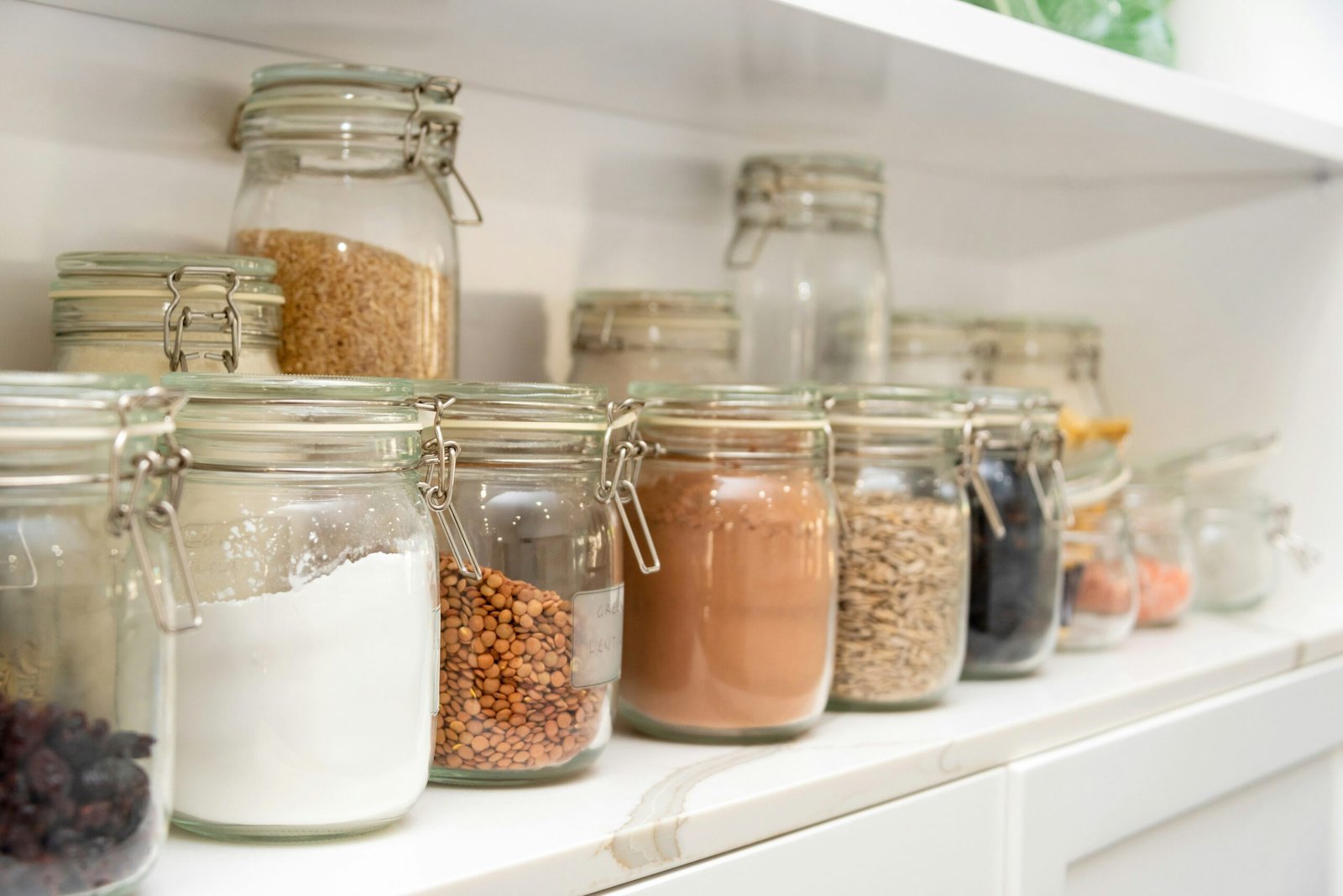 Glass pantry containers organized on kitchen shelves