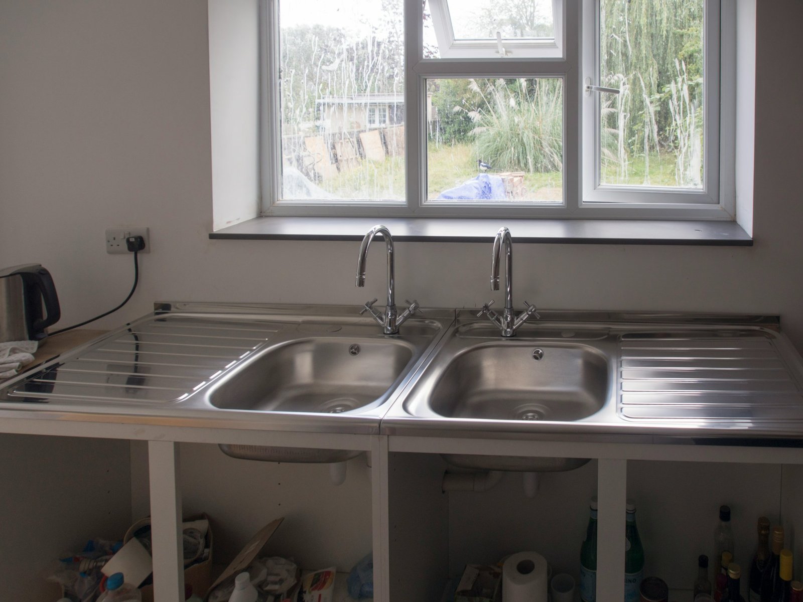 Under sink cabinet storage arranged around kitchen plumbing