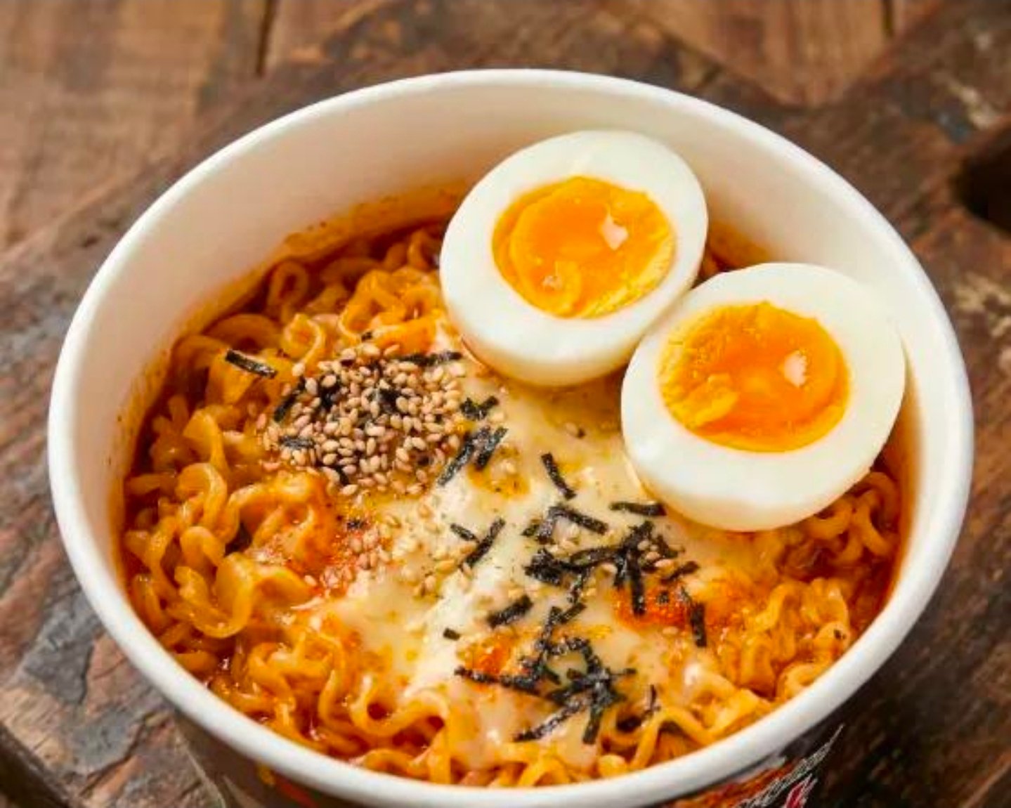 Buldak ramen bowl with melted cheese and soft-boiled eggs