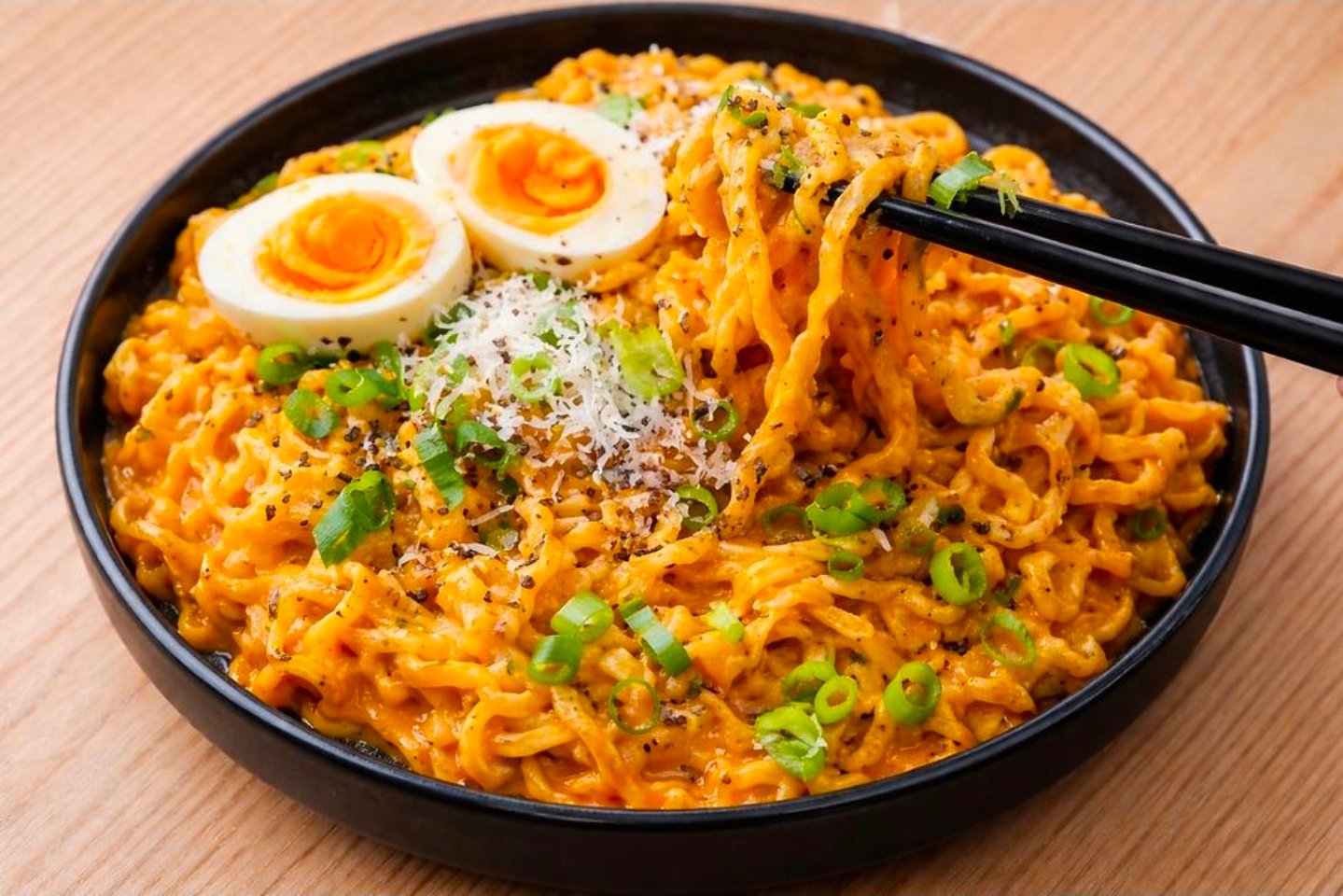 Chopsticks lifting creamy cheese Buldak ramen close up